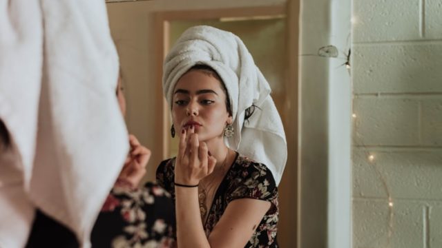 鏡の前で化粧をする女性
